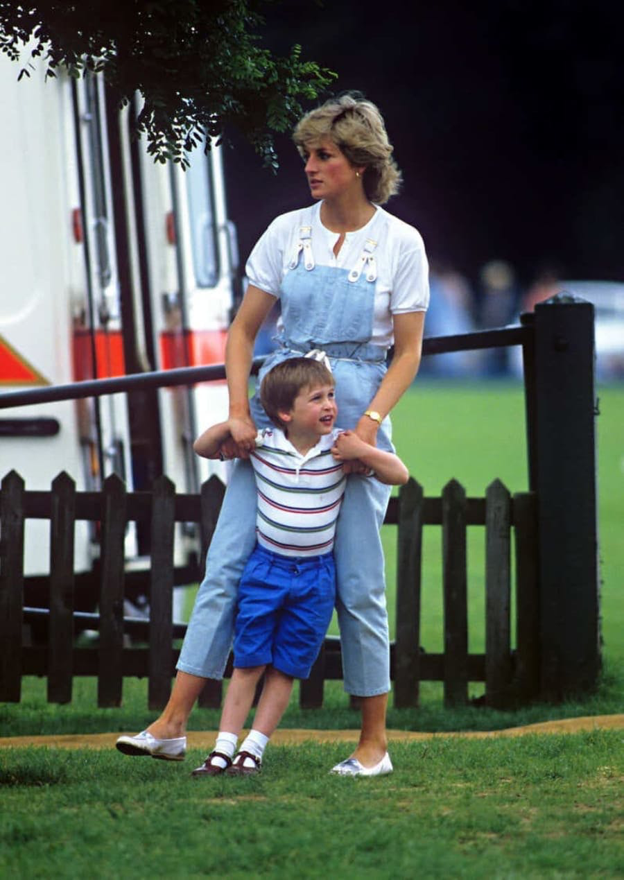 Princesa Diana (Lady Di) usando uma jardineira em jeans acompanhada de seu filho